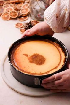 a person holding a pan filled with food on top of a white plate next to other plates