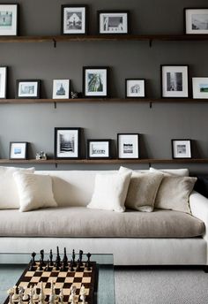 a living room filled with furniture and framed pictures