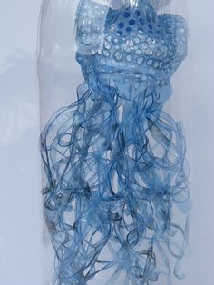 a blue jellyfish in a clear plastic container