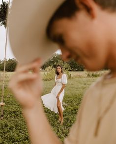 a woman in a white dress is holding a frisbee and looking at it