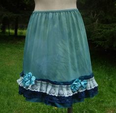 This slip skirt is hand dyed in a blue-green color pallet is a great addition to your warm weather wardrobe. At the hem, turquoise flowers with sparkle bead centers are a great addition to to the lace and satin layers. Waist 21-30 inches, length 18 inches Spring Faerie, Flowers With Beads, Complimenting Colors, Jade Vine, Turquoise Flowers, Slip Skirt, Flowy Skirt, Color Pallets, Green Color