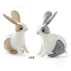 two stuffed rabbits sitting next to each other in front of a white background with chinese characters