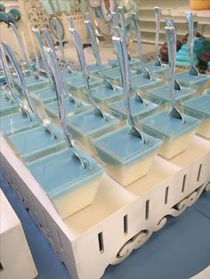 several rows of blue and white trays with spoons sticking out of them on a table