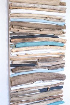 driftwood wall hanging on the wall with blue and white strips attached to each piece