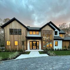 a large house with lots of windows on the front and side of it at dusk