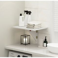 a white sink and some towels on a shelf next to a washer dryer