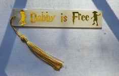 a keychain with a tassel on it that says,'dobby is free '