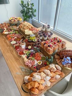 a wooden table topped with lots of different types of foods and pastries on it