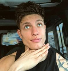 a young man is sitting in the back seat of a car