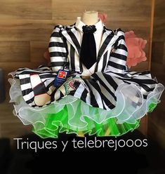 a mannequin dressed in black and white striped clothing with green ruffles