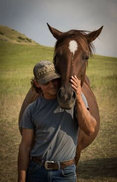 a man standing next to a brown horse