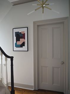 the door is open and there is a framed painting on the wall next to it