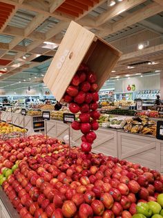 apples are stacked on top of each other in a produce section at a grocery store