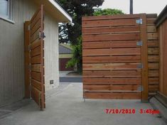 two wooden gates are open in front of a house