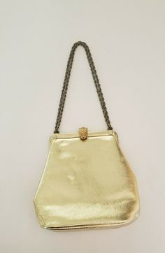 Listing is for a Vintage Wearwell Faux Metallic Gold Evening Bag with a Chain shoulder Strap and clasp closure. Bag measures 7" wide at largest point and 7" tall. Strap can be doubled or used as a single shoulder strap. This item is in excellent preowned condition. Appears unused on the inside. See photos. Shipped USPS Priority Mail. Party Clutch Satchel With Chain Strap, Evening Satchel With Chain Strap And Pouch Shape, Evening Satchel With Chain Strap In Pouch Shape, Evening Pouch Satchel With Chain Strap, Evening Satchel With Chain Strap Pouch, Gold Leather Bags With Chain Strap, Classic Gold Shoulder Bag As Fashion Accessory, Chic Gold Satchel Shoulder Bag, Gold Party Satchel