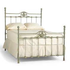 a white metal bed frame with two pillows