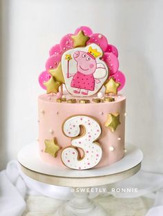 a peppa pig birthday cake with stars and decorations on the top, sitting on a pedestal