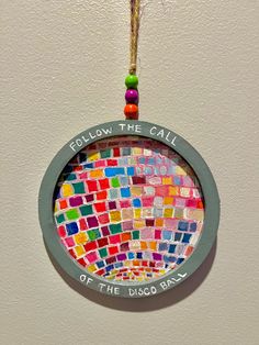 there is a colorful mosaic glass ornament hanging on the wall