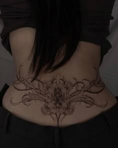 a woman's lower back tattoo with flowers on it