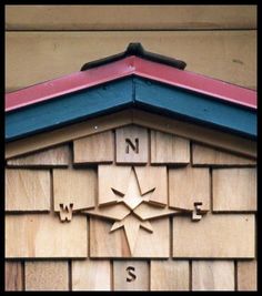 a wooden building with a compass on the side