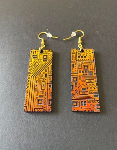 "These stunning STEM inspired acrylic earrings are sure to be your favorite pair! An array of circuits decorate these rectangular shaped dangle earrings. The sunset iridescent finish shifts from orange to green, making them look very futuristic and high tech. The earrings are very lightweight and airy, so they are comfortable to wear all day! The perfect gift for your favorite engineer or STEM professional. Details: * Designed and created by Elishka Jepson * Sunset iridescent shifts acrylic shif Cyberpunk Accessories, Tech Jewelry, Watercolor Bookmarks, Acrylic Jewelry, Funky Earrings, Recycled Jewelry, Clay Jewelry Diy, Acrylic Jewellery, Nerd Geek