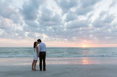 a couple kissing on the beach at sunset