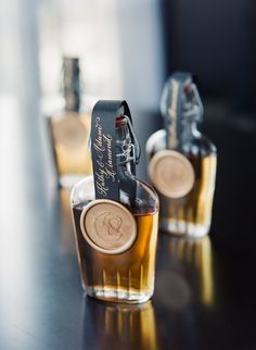 two bottles of liquor sitting on top of a table next to each other with labels