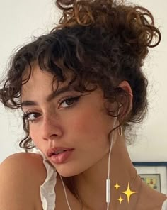 a woman with curly hair wearing ear buds