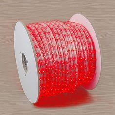 a spool of red led tape on a wooden surface