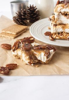 three pieces of dessert sitting on top of a table next to crackers and a glass of milk