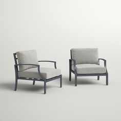 two chairs sitting next to each other on a white surface