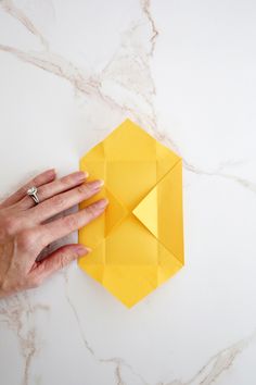 a person holding an origami piece on top of a table