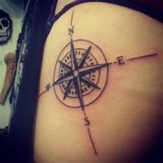 a woman's thigh with a compass tattoo on it