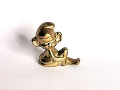 a gold monkey figurine sitting on the ground with its legs crossed and eyes closed