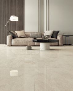 a modern living room with white marble floors and walls, including a large sectional sofa