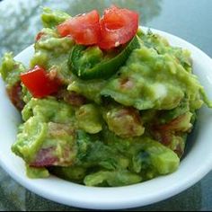 an avocado with tomatoes, lettuce and other toppings