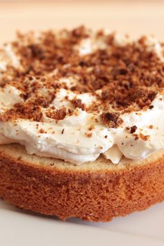 a cake with white frosting and brown sprinkles