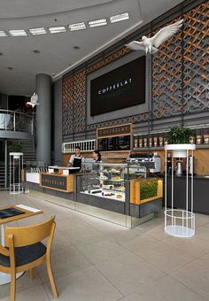 the interior of a coffee shop with tables, chairs and counter top items on display