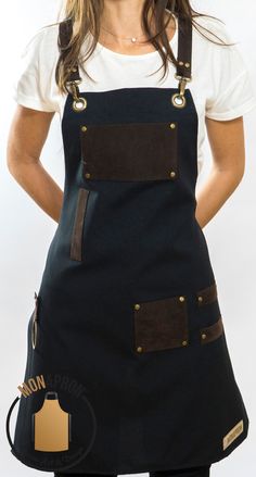 a woman wearing an apron and smiling at the camera with her hands on her hips