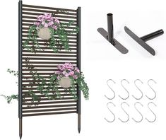 two flower pots are hanging on the side of a metal rack with hooks and flowers