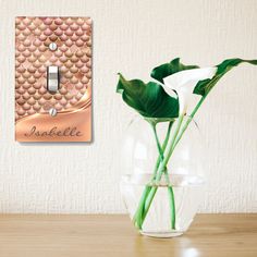 there is a vase with flowers in it and a light switch plate on the wall