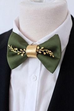 a man wearing a green bow tie with gold leaves on it's lapel