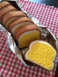 there is a sandwich that has been cut in half and placed on a red checkered table cloth