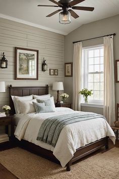 a bedroom with a bed, ceiling fan and two pictures on the wall above it