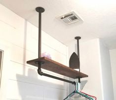 a shelf with some clothes hanging from it's sides next to a ceiling fan