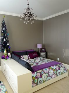 a bed room with a neatly made bed and a christmas tree