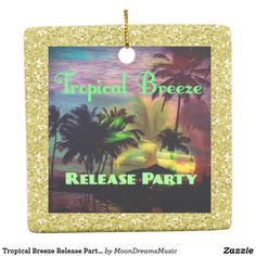 a tropical breeze party ornament hanging from a string on a white background with gold glitter