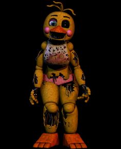 a creepy looking yellow and orange toy with splattered paint on it's body