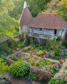 an aerial view of a garden with lots of flowers and plants in the foreground