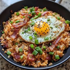 a skillet filled with rice, bacon and an egg